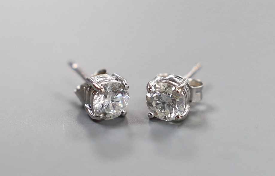 A pair of modern 750 white metal and solitaire diamond set ear studs